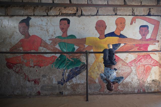 (251225) -- NAIROBI, Dec. 25, 2025 (Xinhua) -- A boy plays on a barre of the Kibera Ballet School at the Kibera slum in Nairobi, Kenya, Dec. 23, 2025. A Christmas ballet performance organized by the Kibera Ballet School was held here on Tuesday, attracting many local residents to watch. (Xinhua/Yang Guang)