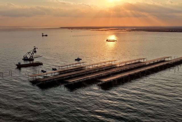 (251225) -- HEBEI, Dec. 25, 2025 (Xinhua) -- A drone photo taken on Dec. 24, 2025 shows workers operating machines at an offshore photovoltaic power station in waters off Changli County, north China's Hebei Province. (Xinhua/Yang Shiyao)