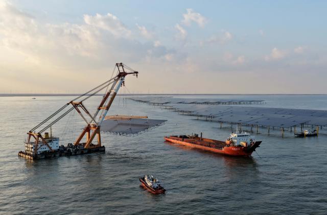 (251225) -- HEBEI, Dec. 25, 2025 (Xinhua) -- A drone photo taken on Dec. 24, 2025 shows workers operating machines at an offshore photovoltaic power station in waters off Changli County, north China's Hebei Province. (Xinhua/Yang Shiyao)