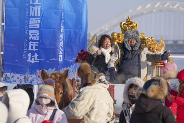 (251225) -- HARBIN, Dec. 25, 2025 (Xinhua) -- People have fun at Harbin Songhua River Ice and Snow Carnival in Harbin, northeast China's Heilongjiang Province, Dec. 25, 2025. The ice and snow carnival here kicked off on Thursday. (Xinhua/Wang Song)