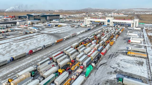 (251225) -- MANZHOULI, Dec. 25, 2025 (Xinhua) -- An aerial drone photo taken on Dec. 3, 2025 shows cargo trucks queuing to go through the Manzhouli land port in Manzhouli City, north China's Inner Mongolia Autonomous Region. Manzhouli City, a historic port city on the China-Russia border, has been unleashing its vigor in city development with continuously deepening of opening-up. According to data released by the Manzhouli station of exit and entry frontier inspection, the Manzhouli port has handled over 900,000 inbound and outbound passenger trips this year as of Dec. 23. (Photo by Xiao Jianbo/Xinhua)