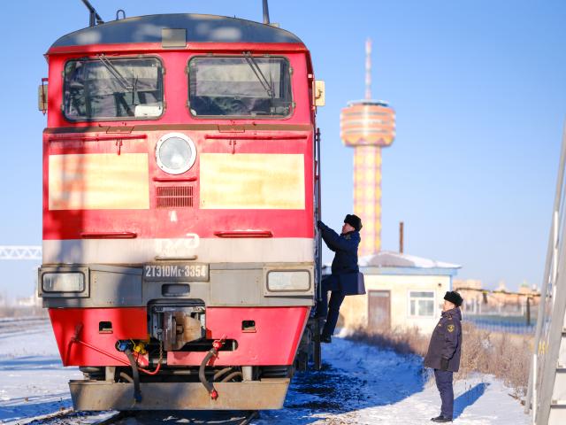 (251225) -- MANZHOULI, Dec. 25, 2025 (Xinhua) -- Customs staff check an inbound China-Europe freight train at Manzhouli Railway Station in Manzhouli City, north China's Inner Mongolia Autonomous Region, Dec. 24, 2025. Manzhouli City, a historic port city on the China-Russia border, has been unleashing its vigor in city development with continuously deepening of opening-up. According to data released by the Manzhouli station of exit and entry frontier inspection, the Manzhouli port has handled over 900,000 inbound and outbound passenger trips this year as of Dec. 23. (Xinhua/Ma Jinrui)