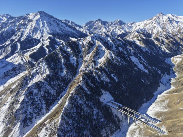 (251225) -- URUMQI, Dec. 25, 2025 (Xinhua) -- An aerial drone photo taken on Dec. 23, 2025 shows a view of Urumqi-Yuli Expressway that traverses the Tianshan Mountains in northwest China's Xinjiang Uygur Autonomous Region. The Tianshan Shengli Tunnel, the world's longest expressway tunnel, and the Urumqi-Yuli Expressway that traverses the Tianshan Mountains via the tunnel, will be open to traffic by the end of this year, enabling a new shortcut linking southern and northern parts of Xinjiang.
  The 22.13-kilometer tunnel will reduce the time it takes to drive across the middle section of the Tianshan Mountains from several hours to about 20 minutes.
   Once operational, the travel time from the regional capital of Urumqi, north of the Tianshan Mountains, to Korla, south of the Tianshan Mountains, will be shortened from seven hours to about three hours. (Xinhua/Hu Huhu)