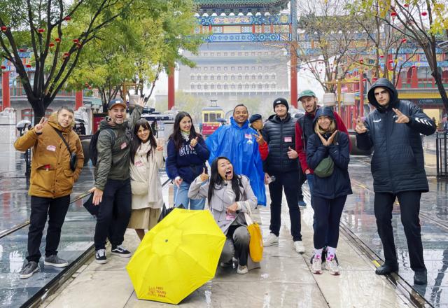(251225) -- SHANGHAI, Dec. 25, 2025 (Xinhua) -- This photo taken in November of 2024 shows Sun Shuli posing for a photo with foreign tourists she leads on the Qianmen pedestrian street in Beijing, capital of China. Sun, who has worked in inbound tourism for years, now leads teams offering in-depth "citywalk" tours and cultural experiences in Beijing and Shanghai. As China's latest chapter of inbound tourism begins to take shape, there are a loosely connected group of people who do not fit neatly into media narratives or influencer culture. They are present in everyday encounters, helping visitors bridge the gap between assumption and experience. In China's media and academic cultural communication circles, people have begun calling them "cultural ferrymen."
     Some are Chinese professionals who have turned away from conventional tourism; others are foreigners who have built their lives in China and now find themselves translating it. Together, they are reshaping how international visitors experience the country -- not as a spectacle, but as a lived reality. (Xinhua)