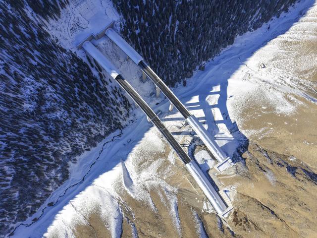 (251225) -- URUMQI, Dec. 25, 2025 (Xinhua) -- An aerial drone photo taken on Dec. 23, 2025 shows Houxia Tunnel (L) and Haxionggou Tunnel on Urumqi-Yuli Expressway in northwest China's Xinjiang Uygur Autonomous Region. The Tianshan Shengli Tunnel, the world's longest expressway tunnel, and the Urumqi-Yuli Expressway that traverses the Tianshan Mountains via the tunnel, will be open to traffic by the end of this year, enabling a new shortcut linking southern and northern parts of Xinjiang.
  The 22.13-kilometer tunnel will reduce the time it takes to drive across the middle section of the Tianshan Mountains from several hours to about 20 minutes.
   Once operational, the travel time from the regional capital of Urumqi, north of the Tianshan Mountains, to Korla, south of the Tianshan Mountains, will be shortened from seven hours to about three hours. (Xinhua/Hu Huhu)
