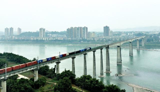 (251225) -- LUZHOU, Dec. 25, 2025 (Xinhua) -- An aerial drone photo taken on Dec. 25, 2025 shows a freight train running on a bridge over the Yangtze River along the Longchang-Luxian-Xuyong railway in Luzhou, southwest China's Sichuan Province. The Longchang-Luxian-Xuyong railway began operation on Thursday as part of China's New International Land-Sea Trade Corridor rail service, which is a crucial logistics link between China's western inland regions and global markets. (Photo by Liao Shengchun/Xinhua)