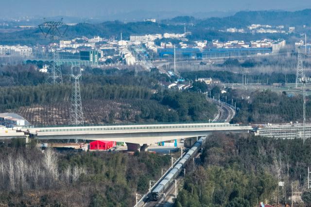 (251225) -- XIANNING, Dec. 25, 2025 (Xinhua) -- An aerial drone photo taken on Dec. 25, 2025 shows a swivel bridge along the Xianning Guihua-Tingsi expressway after being rotated to its desired position over the Beijing-Guangzhou high-speed railway, in Xianning City, central China's Hubei Province. The swivel bridge along the expressway successfully rotated to its desired position here on Thursday. 
   The swivel bridge, with a total length of 378.5 meters and a width of 32.26 meters, weighs 22,000 tons. It is built as a dual four-lane structure with a designed speed of 120 kilometers per hour.
   Upon completion, the Xianning Guihua-Tingsi expressway will play a significant role in improving regional road network efficiency and promoting local economic development. (Xinhua/Wu Zhizun)