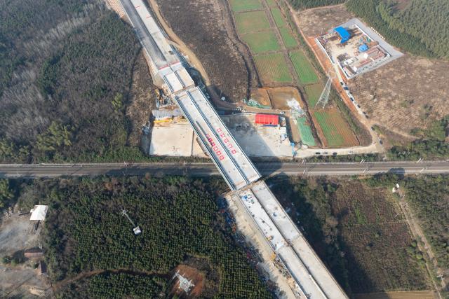 (251225) -- XIANNING, Dec. 25, 2025 (Xinhua) -- An aerial drone photo taken on Dec. 25, 2025 shows a swivel bridge along the Xianning Guihua-Tingsi expressway after being rotated to its desired position over the Beijing-Guangzhou high-speed railway, in Xianning City, central China's Hubei Province. The swivel bridge along the expressway successfully rotated to its desired position here on Thursday. 
   The swivel bridge, with a total length of 378.5 meters and a width of 32.26 meters, weighs 22,000 tons. It is built as a dual four-lane structure with a designed speed of 120 kilometers per hour.
   Upon completion, the Xianning Guihua-Tingsi expressway will play a significant role in improving regional road network efficiency and promoting local economic development. (Xinhua/Wu Zhizun)