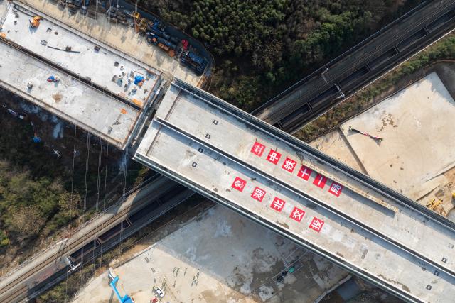 (251225) -- XIANNING, Dec. 25, 2025 (Xinhua) -- An aerial drone photo taken on Dec. 25, 2025 shows a swivel bridge along the Xianning Guihua-Tingsi expressway after being rotated to its desired position over the Beijing-Guangzhou high-speed railway, in Xianning City, central China's Hubei Province. The swivel bridge along the expressway successfully rotated to its desired position here on Thursday. 
   The swivel bridge, with a total length of 378.5 meters and a width of 32.26 meters, weighs 22,000 tons. It is built as a dual four-lane structure with a designed speed of 120 kilometers per hour.
   Upon completion, the Xianning Guihua-Tingsi expressway will play a significant role in improving regional road network efficiency and promoting local economic development. (Xinhua/Wu Zhizun)