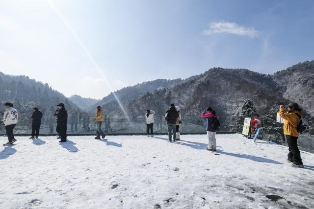 (251225) -- HANGZHOU, Dec. 25, 2025 (Xinhua) -- Tourists enjoy the scenery after snow in the Daming Mountain scenic area in Lin'an District of Hangzhou, east China's Zhejiang Province, on Dec. 25, 2025. Hangzhou's Daming Mountain scenic area saw snowfall under the influence of recent cold air. (Xinhua/Xu Yu)