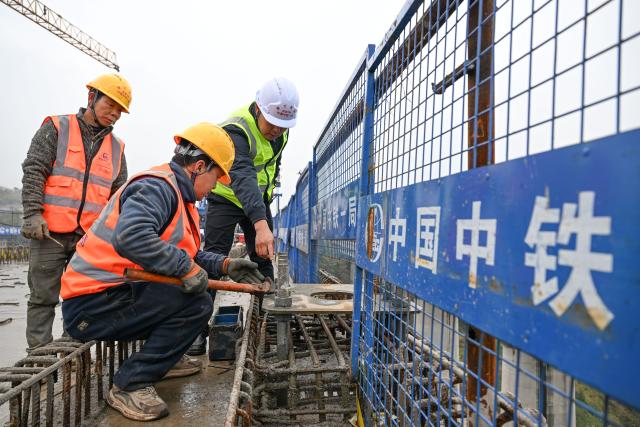 (251225) -- CHONGQING, Dec. 25, 2025 (Xinhua) -- Constructors work at the construction site of a bridge along the Chongqing-Wanzhou high-speed railway in southwest China's Chongqing Municipality, Dec. 25, 2025. Upon completion, the Chongqing-Wanzhou high-speed railway, with a designed speed of 350 km per hour, will shorten travel time from downtown Chongqing to Wanzhou District to less than one hour. (Xinhua/Chen Cheng)