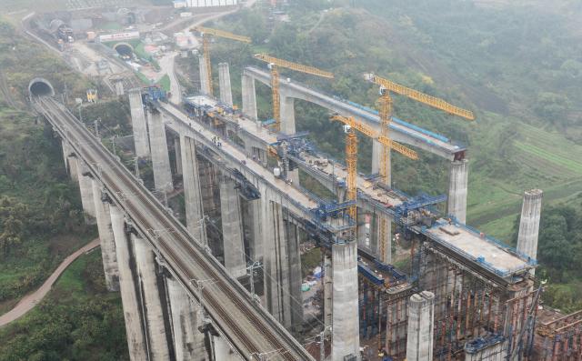 (251225) -- CHONGQING, Dec. 25, 2025 (Xinhua) -- An aerial drone photo taken on Dec. 25, 2025 shows a bridge along the Chongqing-Wanzhou high-speed railway under construction in southwest China's Chongqing Municipality. Upon completion, the Chongqing-Wanzhou high-speed railway, with a designed speed of 350 km per hour, will shorten travel time from downtown Chongqing to Wanzhou District to less than one hour. (Xinhua/Chen Cheng)