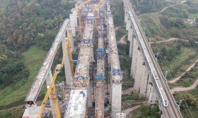 (251225) -- CHONGQING, Dec. 25, 2025 (Xinhua) -- An aerial drone photo taken on Dec. 25, 2025 shows a bridge along the Chongqing-Wanzhou high-speed railway under construction in southwest China's Chongqing Municipality. Upon completion, the Chongqing-Wanzhou high-speed railway, with a designed speed of 350 km per hour, will shorten travel time from downtown Chongqing to Wanzhou District to less than one hour. (Xinhua/Chen Cheng)