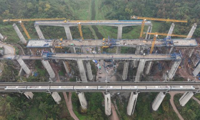 (251225) -- CHONGQING, Dec. 25, 2025 (Xinhua) -- An aerial drone photo taken on Dec. 25, 2025 shows a bridge of the Chongqing-Wanzhou high-speed railway under construction in southwest China's Chongqing Municipality. Upon completion, the Chongqing-Wanzhou high-speed railway, with a designed speed of 350 km per hour, will shorten travel time from downtown Chongqing to Wanzhou District to less than one hour. (Xinhua/Chen Cheng)