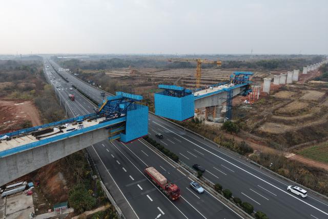(251225) -- QUZHOU, Dec. 25, 2025 (Xinhua) -- A drone photo taken on Dec. 25, 2025 shows the construction site of the continuous beam of the Qujiang grand bridge along the Quzhou-Lishui railway in Quzhou, east China's Zhejiang Province. The 160-km rail line linking Quzhou City and Lishui City in east China's Zhejiang Province will further improve the regional railway network, effectively promote local tourism development. (Xinhua/Huang Zongzhi)
