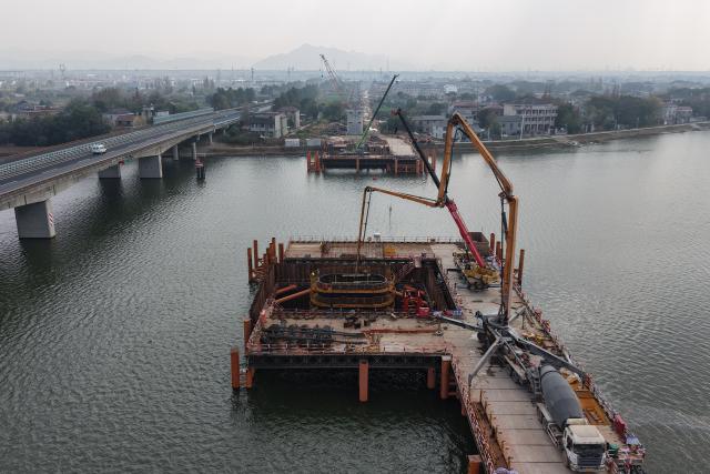 (251225) -- QUZHOU, Dec. 25, 2025 (Xinhua) -- A drone photo taken on Dec. 25, 2025 shows the construction site of the Qujiang grand bridge along the Quzhou-Lishui railway in Quzhou, east China's Zhejiang Province. The 160-km rail line linking Quzhou City and Lishui City in east China's Zhejiang Province will further improve the regional railway network, effectively promote local tourism development. (Xinhua/Huang Zongzhi)