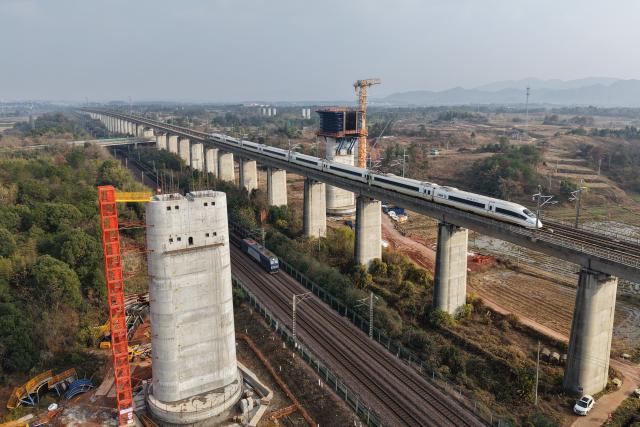 (251225) -- QUZHOU, Dec. 25, 2025 (Xinhua) -- A drone photo taken on Dec. 25, 2025 shows the construction site of the Qujiang grand bridge along the Quzhou-Lishui railway in Quzhou, east China's Zhejiang Province. The 160-km rail line linking Quzhou City and Lishui City in east China's Zhejiang Province will further improve the regional railway network, effectively promote local tourism development. (Xinhua/Huang Zongzhi)