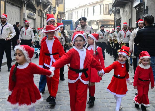 (251225) -- DAMASCUS, Dec. 25, 2025 (Xinhua) -- Photo taken on Dec. 25, 2025, shows Syrian kids dressed in Santa Claus outfits during a Christmas celebration in Damascus, Syria. (Photo by Ammar Safarjalani/Xinhua)