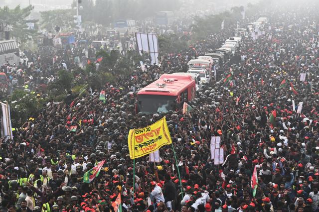 (251225) -- DHAKA, Dec. 25, 2025 (Xinhua) -- Supporters gather along a road as Tarique Rahman, Bangladesh Nationalist Party (BNP)'s acting chairperson and son of ex-Prime Minister Begum Khaleda Zia, arrives in Dhaka, Bangladesh, Dec. 25, 2025. BNP's acting chairperson Rahman returned to the country Thursday after spending 17 years in exile in Britain. (Photo by Habibur Rahman/Xinhua)