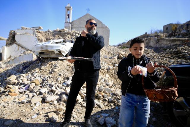 (251226) -- YAROUN, Dec. 26, 2025 (Xinhua) -- Locals distribute sweets on Christmas in front of a church destroyed by the Israeli army during the war, in southern Lebanese village of Yaroun, Dec. 25, 2025. The church had stood for 102 years. (Photo by Ali Hashisho/Xinhua)
