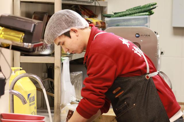 (251226) -- ZHENGZHOU, Dec. 26, 2025 (Xinhua) -- Zhonghang, chef of Chenjiuye noodle shop, works at the kitchen of the shop in Zhengzhou, central China's Henan Province, Dec. 11, 2025. TO GO WITH "Feature: Noodle shop run by hearing-impaired opens door to world beyond silence" (Xinhua/Wang Qianhui)