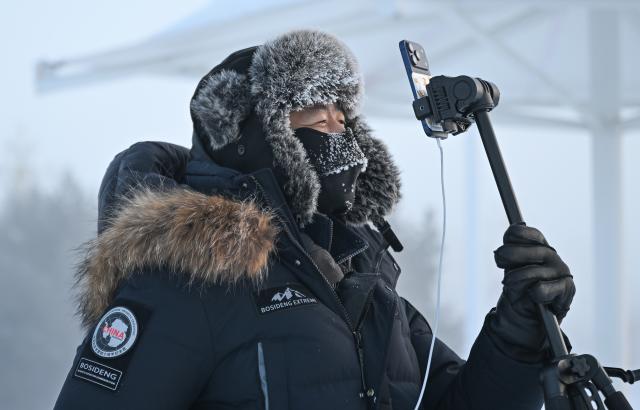 (251226) -- GENHE, Dec. 26, 2025 (Xinhua) -- A video blogger does livestream in Genhe City, north China's Inner Mongolia Autonomous Region, on Dec. 26, 2025. The low temperature in Genhe, known as "China's cold pole," hits minus 45 degrees Celsius on Friday morning. (Xinhua/Bei He)