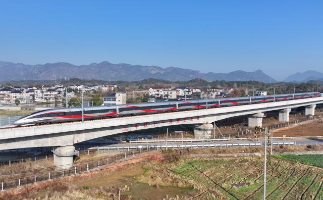 (251226) -- QUZHOU, Dec. 26, 2025 (Xinhua) -- An aerial drone photo taken on Dec. 26, 2025 shows the C3132 passenger train bound for Hangzhou running along the Hangzhou-Quzhou high-speed railway in east China's Zhejiang Province. The 131-km high-speed railway connecting the cities of Hangzhou and Quzhou in Zhejiang puts into operation on Friday. (Xinhua/Huang Zongzhi)