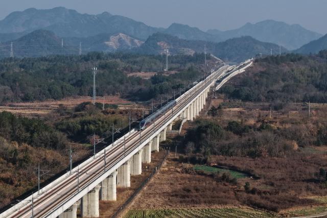 (251226) -- QUZHOU, Dec. 26, 2025 (Xinhua) -- An aerial drone photo taken on Dec. 26, 2025 shows the C3132 passenger train bound for Hangzhou running along the Hangzhou-Quzhou high-speed railway in east China's Zhejiang Province. The 131-km high-speed railway connecting the cities of Hangzhou and Quzhou in Zhejiang puts into operation on Friday. (Xinhua/Huang Zongzhi)