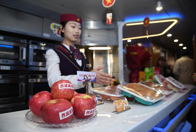 (251226) -- XI'AN, Dec. 26, 2025 (Xinhua) -- A train attendant introduces specialities of Yan'an on the first train of the Xi'an-Yan'an high-speed railway in northwest China's Shaanxi Province, Dec. 26, 2025. A sleek silver bullet train departed Yan'an in northwest China's Shaanxi Province on Friday, linking the sacred revolutionary heartland to the country's rapidly expanding high-speed rail network.
   The newly opened 299-km line connects Yan'an with Xi'an, the provincial capital and home to the famed Terracotta Warriors, slashing travel time between the two cities from about 2.5 hours to roughly one hour.
   Designed for operations of up to 350 km per hour, the line marked the fastest train running on the Loess Plateau. (Xinhua/Zhang Bowen)