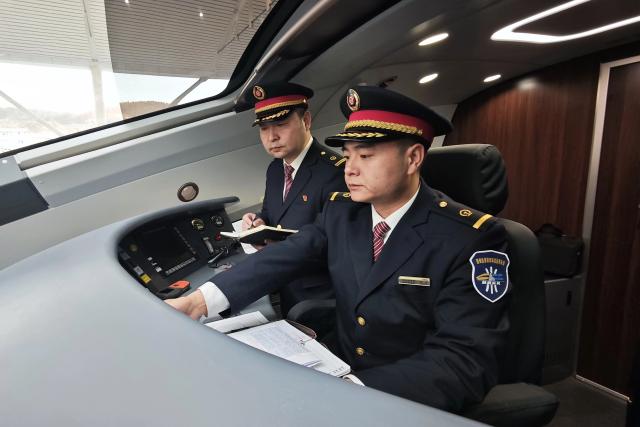 (251226) -- XI'AN, Dec. 26, 2025 (Xinhua) -- Drivers of the first train of the Xi'an-Yan'an high-speed railway make preparations at Yan'an Station in Yan'an, northwest China's Shaanxi Province, Dec. 26, 2025. A sleek silver bullet train departed Yan'an in northwest China's Shaanxi Province on Friday, linking the sacred revolutionary heartland to the country's rapidly expanding high-speed rail network.
   The newly opened 299-km line connects Yan'an with Xi'an, the provincial capital and home to the famed Terracotta Warriors, slashing travel time between the two cities from about 2.5 hours to roughly one hour.
   Designed for operations of up to 350 km per hour, the line marked the fastest train running on the Loess Plateau. (Photo by Cao Xin/Xinhua)