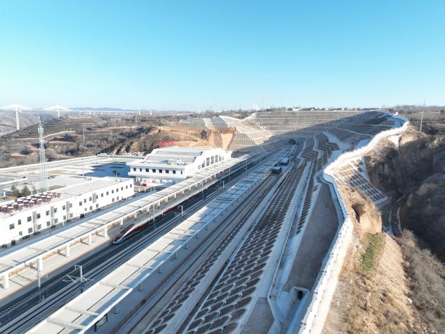 (251226) -- XI'AN, Dec. 26, 2025 (Xinhua) -- An aerial drone photo taken on Dec. 26, 2025 shows a bullet train running past Tongchuan North Railway Station along the Xi'an-Yan'an high-speed railway in northwest China's Shaanxi Province. A sleek silver bullet train departed Yan'an in northwest China's Shaanxi Province on Friday, linking the sacred revolutionary heartland to the country's rapidly expanding high-speed rail network.
   The newly opened 299-km line connects Yan'an with Xi'an, the provincial capital and home to the famed Terracotta Warriors, slashing travel time between the two cities from about 2.5 hours to roughly one hour.
   Designed for operations of up to 350 km per hour, the line marked the fastest train running on the Loess Plateau. (Xinhua)