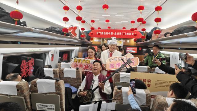 (251226) -- XI'AN, Dec. 26, 2025 (Xinhua) -- People perform on the first train of the Xi'an-Yan'an high-speed railway in northwest China's Shaanxi Province, Dec. 26, 2025. A sleek silver bullet train departed Yan'an in northwest China's Shaanxi Province on Friday, linking the sacred revolutionary heartland to the country's rapidly expanding high-speed rail network.
   The newly opened 299-km line connects Yan'an with Xi'an, the provincial capital and home to the famed Terracotta Warriors, slashing travel time between the two cities from about 2.5 hours to roughly one hour.
   Designed for operations of up to 350 km per hour, the line marked the fastest train running on the Loess Plateau. (Xinhua/Xing Guangli)