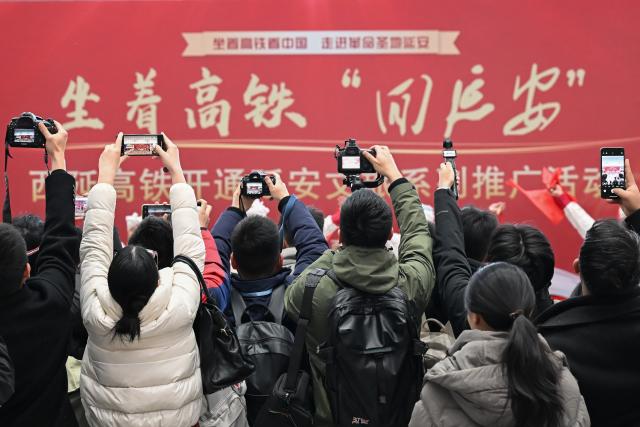 (251226) -- XI'AN, Dec. 26, 2025 (Xinhua) -- Journalists take photos during a promotional event marking the operation of Xi'an-Yan'an high-speed railway at Xi'an North Railway Station in northwest China's Shaanxi Province, on Dec. 26, 2025. A sleek silver bullet train departed Yan'an in northwest China's Shaanxi Province on Friday, linking the sacred revolutionary heartland to the country's rapidly expanding high-speed rail network.
   The newly opened 299-km line connects Yan'an with Xi'an, the provincial capital and home to the famed Terracotta Warriors, slashing travel time between the two cities from about 2.5 hours to roughly one hour.
   Designed for operations of up to 350 km per hour, the line marked the fastest train running on the Loess Plateau. (Xinhua/Zou Jingyi)