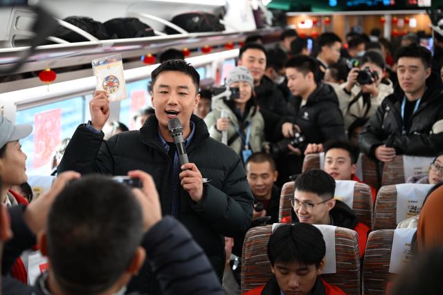 (251226) -- XI'AN, Dec. 26, 2025 (Xinhua) -- A staff member interacts with passengers inside a carriage of the C9312 bullet train of the Xi'an-Yan'an high-speed railway in northwest China's Shaanxi Province, on Dec. 26, 2025. A sleek silver bullet train departed Yan'an in northwest China's Shaanxi Province on Friday, linking the sacred revolutionary heartland to the country's rapidly expanding high-speed rail network.
   The newly opened 299-km line connects Yan'an with Xi'an, the provincial capital and home to the famed Terracotta Warriors, slashing travel time between the two cities from about 2.5 hours to roughly one hour.
   Designed for operations of up to 350 km per hour, the line marked the fastest train running on the Loess Plateau. (Xinhua/Zou Jingyi)