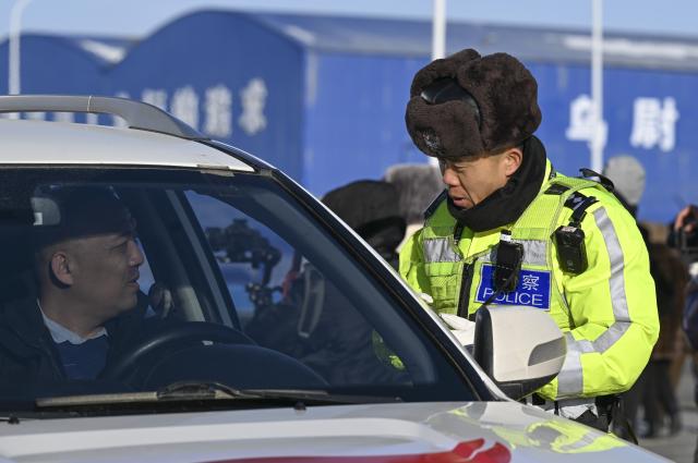 (251226) -- URUMQI, Dec. 26, 2025 (Xinhua) -- A policeman reminds a driver of safety precautions at a toll station for the Urumqi-Yuli Expressway in Urumqi County, northwest China's Xinjiang Uygur Autonomous Region, Dec. 26, 2025. The 22.13-km Tianshan Shengli Tunnel, the world's longest expressway tunnel, officially opened to traffic on Friday.
   Traversing the central Tianshan Mountains in northwest China's Xinjiang Uygur Autonomous Region, the tunnel slashes what was once a several-hour mountain drive to just 20 minutes.
   As a vital artery linking city clusters in northern and southern Xinjiang, the G0711 Urumqi-Yuli Expressway, including the tunnel, entered operation on the same day. (Xinhua/Wang Fei)