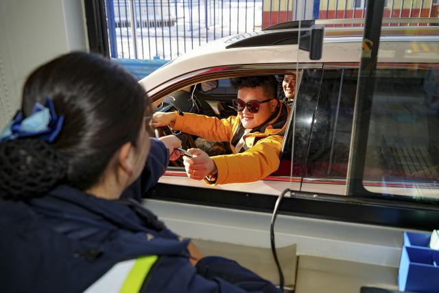 (251226) -- URUMQI, Dec. 26, 2025 (Xinhua) -- A staff member (L) hands a passing card to a driver at a toll station for the Urumqi-Yuli Expressway in northwest China's Xinjiang Uygur Autonomous Region, Dec. 26, 2025. The 22.13-km Tianshan Shengli Tunnel, the world's longest expressway tunnel, officially opened to traffic on Friday.
   Traversing the central Tianshan Mountains in northwest China's Xinjiang Uygur Autonomous Region, the tunnel slashes what was once a several-hour mountain drive to just 20 minutes.
   As a vital artery linking city clusters in northern and southern Xinjiang, the G0711 Urumqi-Yuli Expressway, including the tunnel, entered operation on the same day. (Xinhua/Xu Hongyan)