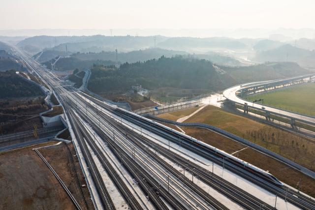 (251226) -- YICHANG, Dec. 26, 2025 (Xinhua) -- An aerial drone photo taken on Dec. 26, 2025 shows a bullet train pulling into the Yichang North Railway Station in Yichang, central China's Hubei Province. The Wuhan-Yichang section of a high-speed railway linking east China's Shanghai, southwest China's Chongqing and Chengdu of southwest China's Sichuan Province was officially put into operation on Friday. 
   With a total length of 314 kilometers and a designed speed of 350 kilometers per hour, the Wuhan-Yichang section of the railway is a part of China's high-speed rail network along the Yangtze River. (Xinhua/Wu Zhizun)