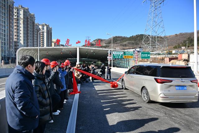 (251226) -- QINGDAO, Dec. 26, 2025 (Xinhua) -- A vehicle drives into the Laohu Mountain Tunnel in Qingdao, east China's Shandong Province, Dec. 26, 2025. The Laohu Mountain Tunnel is an integral part of the Tangshan Road interchange and connection line project along the Qingdao-Yinchuan Expressway, which was opened to traffic on Friday. 
   The tunnel spans a total length of 1,551 meters and features eight lanes in a bidirectional double-tunnel configuration. Its maximum excavation span is 31.8 meters, with a maximum excavation cross-section of 447.62 square meters. (Xinhua/Li Ziheng)