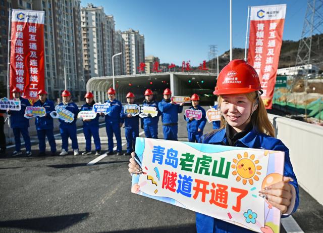 (251226) -- QINGDAO, Dec. 26, 2025 (Xinhua) -- Constructors celebrate the opening of the Laohu Mountain Tunnel in Qingdao, east China's Shandong Province, Dec. 26, 2025. The Laohu Mountain Tunnel is an integral part of the Tangshan Road interchange and connection line project along the Qingdao-Yinchuan Expressway, which was opened to traffic on Friday. 
   The tunnel spans a total length of 1,551 meters and features eight lanes in a bidirectional double-tunnel configuration. Its maximum excavation span is 31.8 meters, with a maximum excavation cross-section of 447.62 square meters. (Xinhua/Li Ziheng)