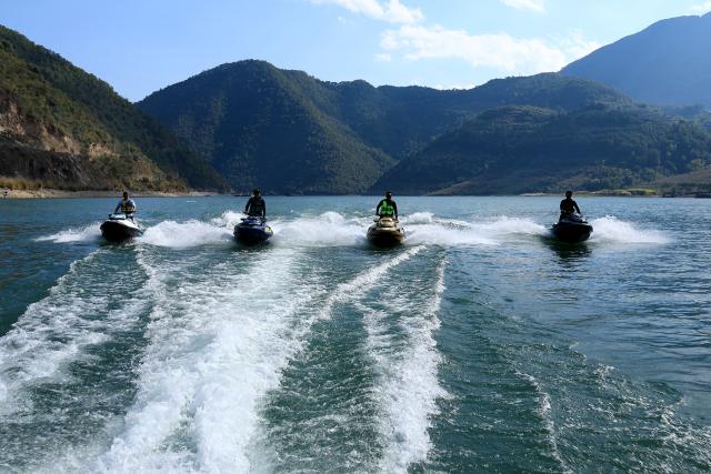(251226) -- NANJIAN, Dec. 26, 2025 (Xinhua) -- People ride jet skis at a water sports base on the Lancang River in Gonglang Town in Nanjian Yi Autonomous County, southwest China's Yunnan Province, Dec. 25, 2025. In recent years, Gonglang Town, boasting an advantageous ecological environment and pleasant climate throughout the year, has actively revitalized the rural economy by developing water sports initiatives and promoting cultural tourism.
   The town has established competitive, training, and experiential settings for a diverse range of open-water sports, and has proactively sought to host sports events and training programs. Additionally, it provides a host of cultural and tourism services, including catering and travel photography. These concerted efforts have created employment opportunities and diversified income sources for local villagers. (Xinhua/Liu Lianfen)