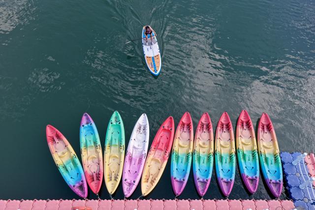 (251226) -- NANJIAN, Dec. 26, 2025 (Xinhua) -- A drone photo taken on Dec. 25, 2025 shows a tourist enjoying paddle boarding at a water sports base on the Lancang River in Gonglang Town in Nanjian Yi Autonomous County, southwest China's Yunnan Province. In recent years, Gonglang Town, boasting an advantageous ecological environment and pleasant climate throughout the year, has actively revitalized the rural economy by developing water sports initiatives and promoting cultural tourism.
   The town has established competitive, training, and experiential settings for a diverse range of open-water sports, and has proactively sought to host sports events and training programs. Additionally, it provides a host of cultural and tourism services, including catering and travel photography. These concerted efforts have created employment opportunities and diversified income sources for local villagers. (Photo by Gong Zujin/Xinhua)