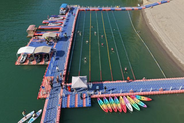 (251226) -- NANJIAN, Dec. 26, 2025 (Xinhua) -- A drone photo taken on Dec. 25, 2025 shows people swimming in the Lancang River in Gonglang Town in Nanjian Yi Autonomous County, southwest China's Yunnan Province. In recent years, Gonglang Town, boasting an advantageous ecological environment and pleasant climate throughout the year, has actively revitalized the rural economy by developing water sports initiatives and promoting cultural tourism.
   The town has established competitive, training, and experiential settings for a diverse range of open-water sports, and has proactively sought to host sports events and training programs. Additionally, it provides a host of cultural and tourism services, including catering and travel photography. These concerted efforts have created employment opportunities and diversified income sources for local villagers. (Xinhua/Liu Lianfen)