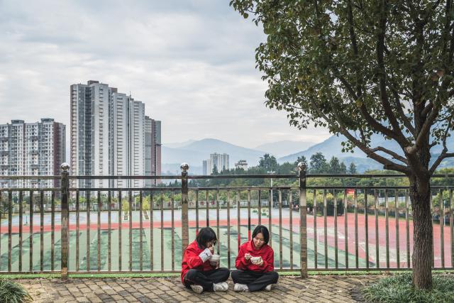 (251226) -- HUAPING, Dec. 26, 2025 (Xinhua) -- Two students have meals outdoors at Huaping Senior High School for Girls in Huaping County, Lijiang City, southwest China's Yunnan Province, Dec. 23, 2025. Each morning at Huaping High School for Girls in Yunnan Province, the schoolyard rings with a bold pledge, "I was born to be a mountain not a creek, rising to the high peaks with the valleys at my feet." Behind that voice stands Zhang Guimei, the school's founder and principal. In her sixties and struggling with illness, she still devotes more than 18 hours a day to her students. Megaphone in hand, she has become a living symbol of how education can open doors that poverty once closed.
   Founded in 2008, Huaping High School for Girls is the country's first senior high school to offer free education for girls. The school in mountainous Yunnan Province has created a miracle, with more than 2,000 graduates -- most of whom come from low-income rural families -- admitted to colleges and universities. Many of them later became teachers, doctors and civil servants, fulfilling their aspirations. (Xinhua/Wang Guansen)
