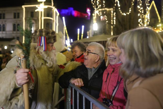 (251226) -- LJUBLJANA, Dec. 26, 2025 (Xinhua) -- A man dressed as Grandpa Frost interacts with older visitors during a procession on the Presernov Square in Ljubljana, Slovenia, Dec. 26, 2025. (Photo by Zeljko Stevanic/Xinhua)