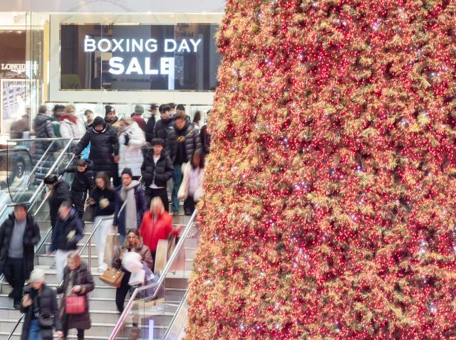 (251226) -- TORONTO, Dec. 26, 2025 (Xinhua) -- People walk past a Boxing Day promotion sign in Toronto, Canada, on Dec. 26, 2025. (Photo by Zou Zheng/Xinhua)