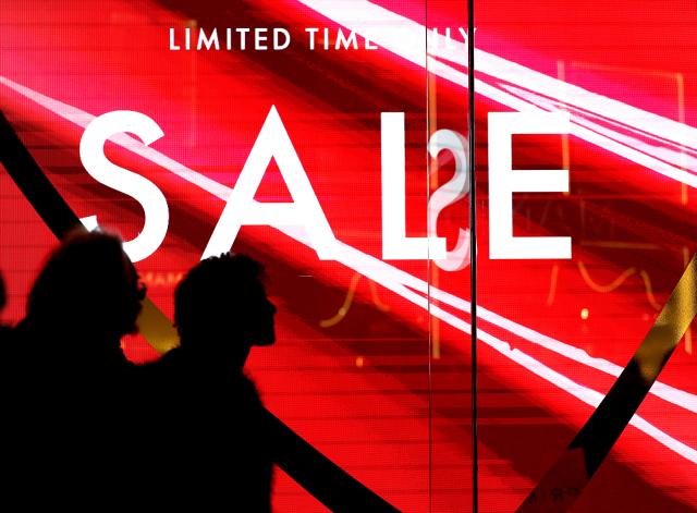 (251226) -- LONDON, Dec. 26, 2025 (Xinhua) -- People walk past a sale sign on Oxford Street during Boxing Day sales in London, Britain, on Dec. 26, 2025. (Xinhua/Li Ying)