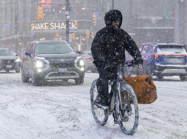 (251227) -- TORONTO, Dec. 27, 2025 (Xinhua) -- A man rides an e-bike during a snowy day in Toronto, Canada, on Dec. 26, 2025. (Photo by Zou Zheng/Xinhua)