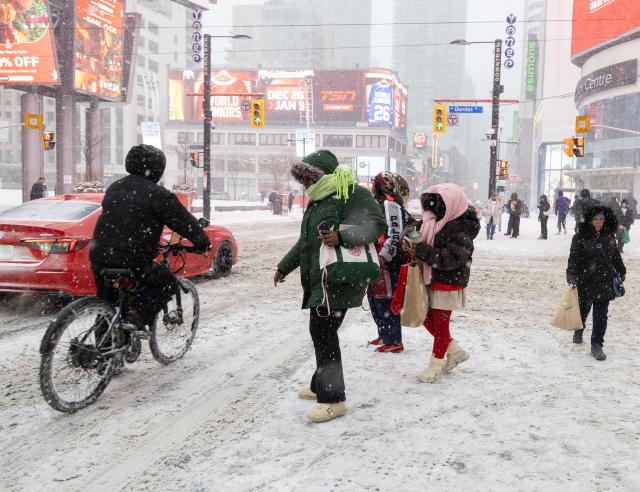 (251227) -- TORONTO, Dec. 27, 2025 (Xinhua) -- People walk on a street during a snowy day in Toronto, Canada, on Dec. 26, 2025. (Photo by Zou Zheng/Xinhua)
