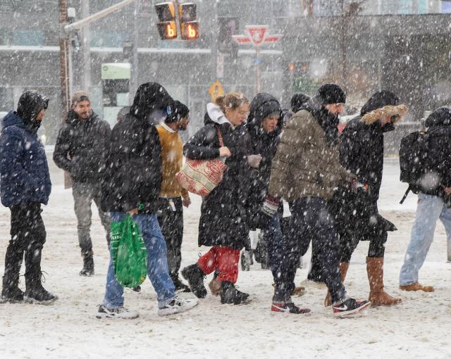 (251227) -- TORONTO, Dec. 27, 2025 (Xinhua) -- People walk on a street during a snowy day in Toronto, Canada, on Dec. 26, 2025. (Photo by Zou Zheng/Xinhua)