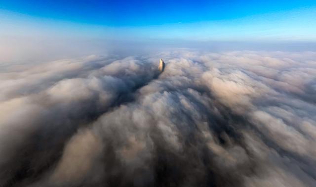 (251227) -- BEIJING, Dec. 27, 2025 (Xinhua) -- This aerial photo taken on Dec. 26, 2025 shows building shrouded by fog and cloud in Kuwait City, Kuwait. (Photo by Asad/Xinhua)